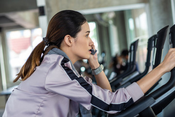 Smart asian beautiful women exercise with bike in sport gym