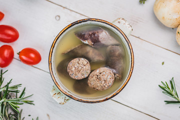 liverwurst in broth. soup with a pot.