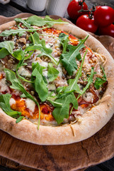 Homemade pizza with arugula, nuts and cheese