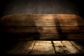 Wooden desk of free space and dark mood background.