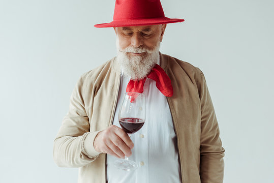 Handsome Elderly Man In Red Hat Holding Glass Of Wine Isolated On White