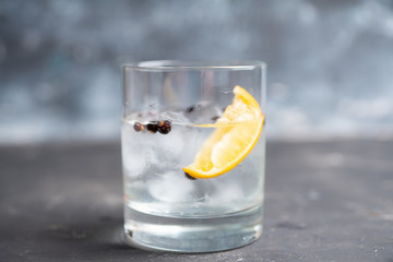 Gin based cocktail with lemon slice and juniper berries. Selective focus. Shallow depth of field.