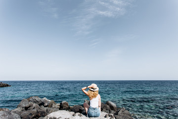 Girl sitting on a rocky beach