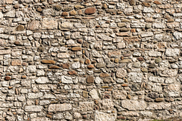 Close-up of a wall made with river pebbles and irregular shaped stones, full frame, background. Trento, Trentino Alto Adige, Italy, Europe