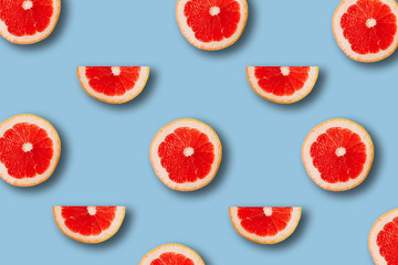 summer pattern with red juicy ripe fresh grapefruit on a blue background