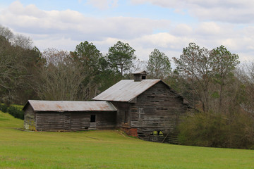 Fototapeta na wymiar old vintage riverbank country farm barn building sunny cloudy sky