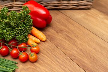 Fresh vegetables lie on the board on the background of the basket