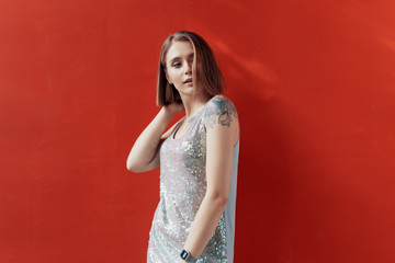 Cheerful young girl posing in front of a red wall