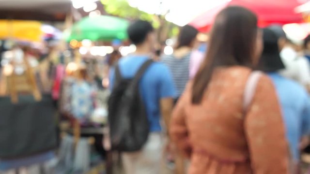 Slow motion speed blur scene on group of traveler traveling in local craft market, tourist relax walking and enjoy shopping in street food shop, buyer look for goods to buy