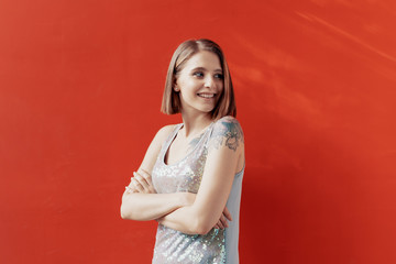 Fototapeta premium Cheerful young girl posing in front of a red wall