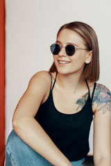 Young girl sitting on a white chair near the red wall