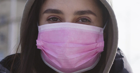 Outdoor portrait of young woman wearing protective mask