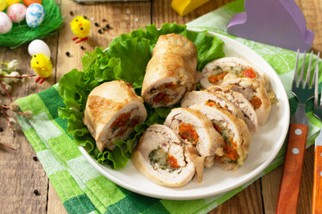 Festive appetizer. Chicken meatloaf with dried apricots, mozzarella and herbs on a festive Easter table.