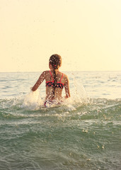 Beautiful Teen Girl playing In Sea Waves. Jump Accompanied By Water Splashes. Summer  Day, Happy childhood, Ocean Coast concept