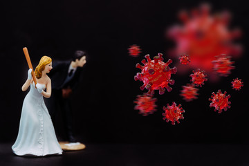 Bride and Groom holding baseball bat hitting Covid-19 Coronavirus cell coming to attack and destroy wedding ceremony.Social distancing.Lover couple Fight back virus corona covid19.Black background.