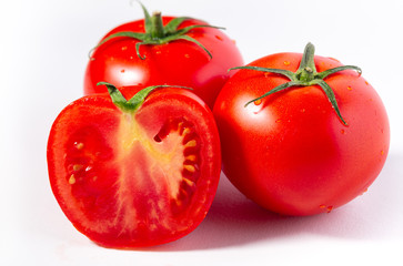 Fresh ripe greenhouse grown tomatoes on a white surface