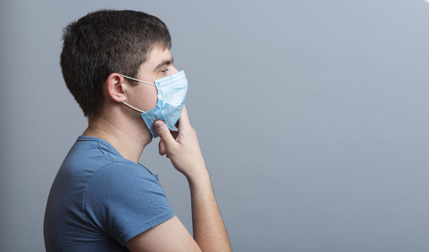 Profile Serious Young Doctor In Protective Medical Mask Thinking On Gray Studio Background, Concept Medicine And Health,specialist Forms An Opinion About The Situation