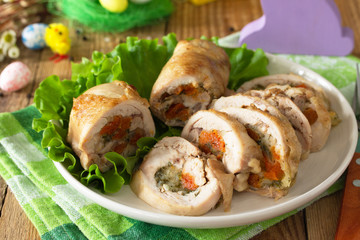 Festive appetizer close-up. Chicken meatloaf with dried apricots, mozzarella and herbs on a festive Easter table.