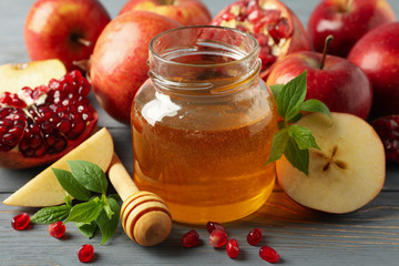 Apple, honey and pomegranate on wooden background, close up. Home treatment