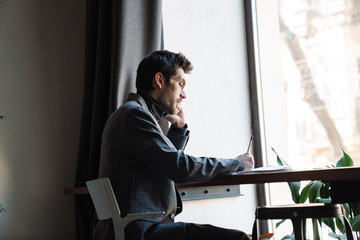 Image of businessman examining documents and talking cellphone