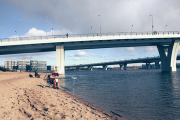 Men in early spring fishing from the shore under the bridge.