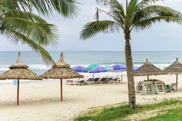 Obraz na płótnie Canvas Palms and sunbeds in China Beach in Da Nang