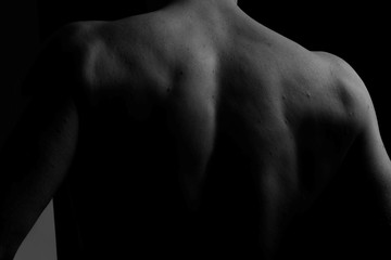Back. The back of the man. Man holding a chain on his back in both hands. Chain. Black and white photo. Power. Sports Hall. - obrazy, fototapety, plakaty