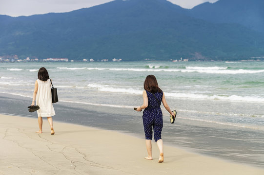Young girls passing by on China Beach in Danang