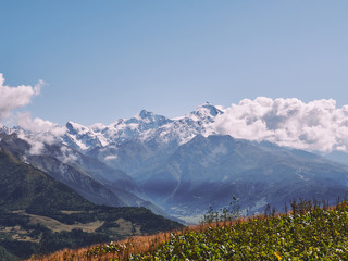 Fototapeta premium The majestic peak of Tetnuldi covered with snow on a sunny summer day in Caucasus mountains