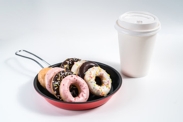 Donuts and drink and iron frying panon white background top view copy space pattern