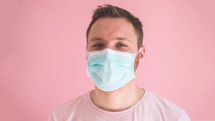 A man in a viral mask on a pink background, wearing face protection in prevention for coronavirus