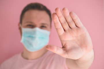 A man in a viral mask on a pink background, wearing face protection in prevention for coronavirus
