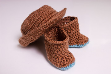 Knitted hat and boots. Knitted shoes and clothes. Booties for babies.