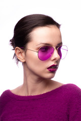 girl in a purple sweater, purple glasses with purple lipstick on her lips