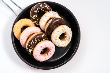 Donuts and drink and iron frying panon white background top view copy space pattern