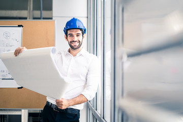 Caucasian young engineer home building member smile with new project planning while hold paper. The man hold blueprint of structure control in meeting room. Structure analysis home building concept.