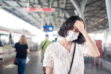 Asian woman wearing mask for prevent dusk pm 2.5 bad air pollution and coronavirus or covid-19 spreading over Asia.  Girl wearing mask due to bad smell and prevent virus infection from people in city.