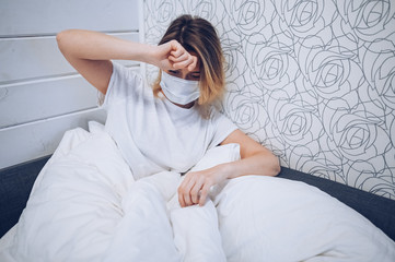 Coronavirus disease (COVID-19) symptoms are a runny nose, sore throat, cough, and fever. Young woman sick of coronavirus viral infection spreading corona virus. Patient lying in bed at home quarantine