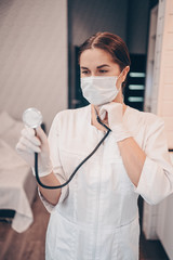 Woman doctor nurse wearing protective mask and stethoscope for check breathing, corona virus prevention, hygiene to stop spreading coronavirus. Avoid contaminating Corona virus Covid-19 concept