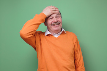 Happy man euphoric surprised by unbelievable offer on green wall