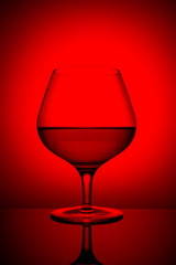 Fototapeta na wymiar single glass with red wine on a colored background