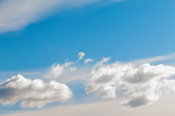 Naklejka na ściany i meble Cumulus and cirrus clouds in bright blue sky