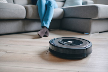 Robotic vacuum cleaner on wood floor in modern living room