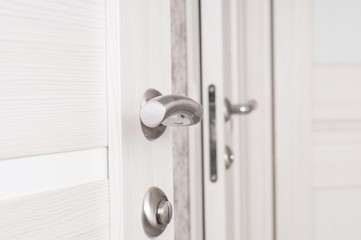 Metallic door handle on a wooden door close up