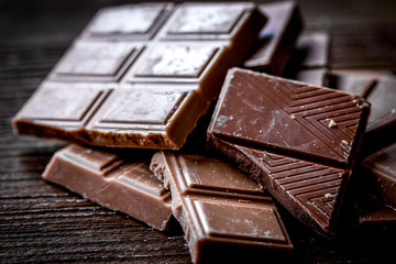 chopped chocolate pieces for dessert dark wooden desk background
