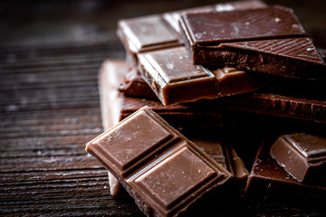 black and milk chocolate bars dark wooden table background