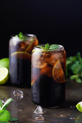 Cuba Libre or long island iced tea cocktail with strong drinks, cola, lime and ice in glass, cold longdrink or lemonade