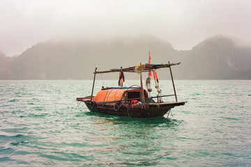 Fototapeta premium Fishing boat in Ha Long Bay Vietnam at sunset Asia