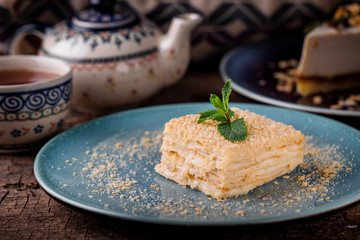  a piece of napoleon cake on a blue plate on a wooden table with mint