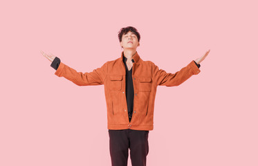 Portrait of asian handsome young man standing and hands up with close your eyes begging from god